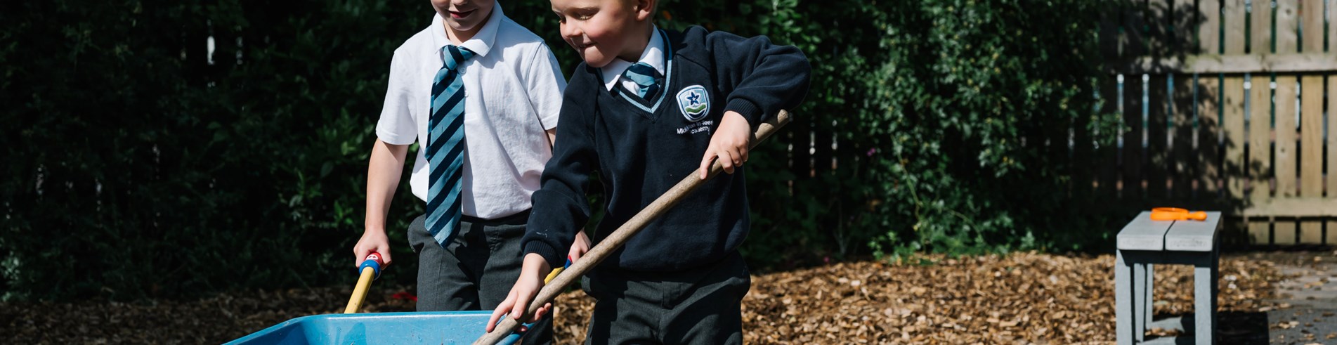 Pupils playing with wheelbarrow