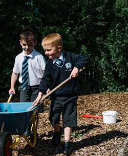 Pupils playing with wheelbarrow
